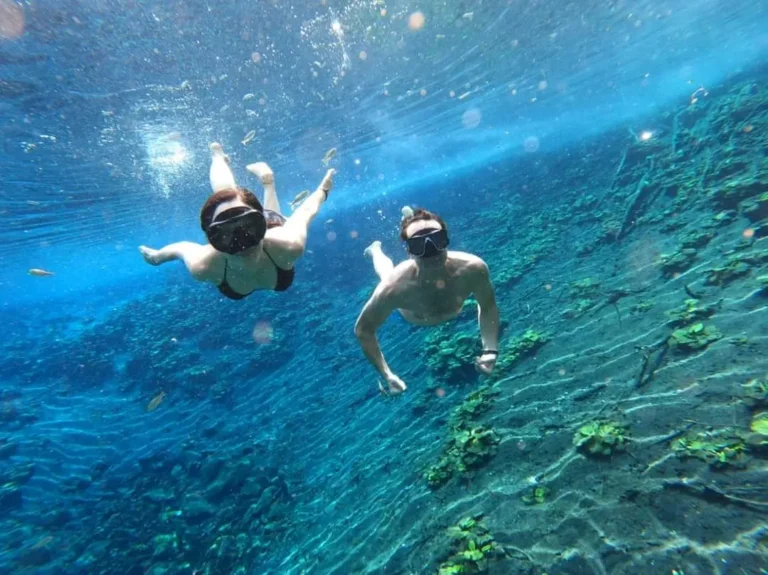 Pareja buceando en el Cráter Azul, Petén, tour desde Flores