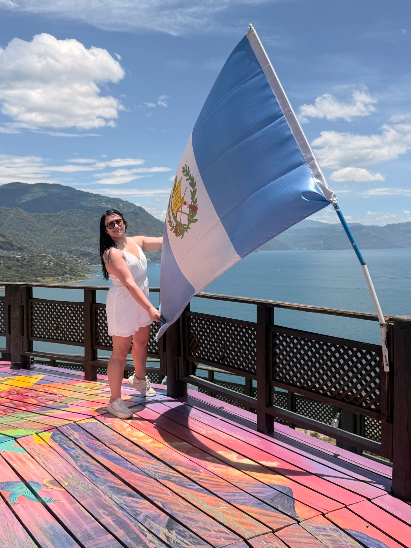 Turista con bandera de Guatemala en un mirador de San Pedro la Laguna, Lago de Atitlán