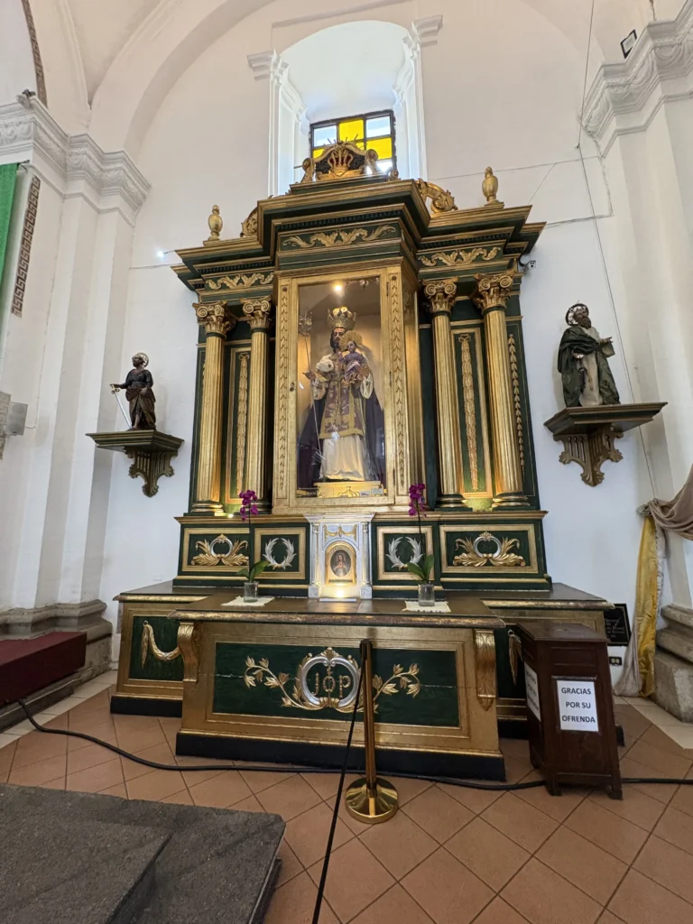 Retablo dorado y verde con imagen venerada en la Catedral de Antigua Guatemala
