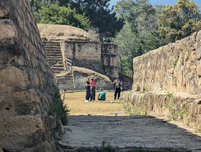 Muros de piedra y plaza de Iximché con visitantes, Tecpán, Guatemala