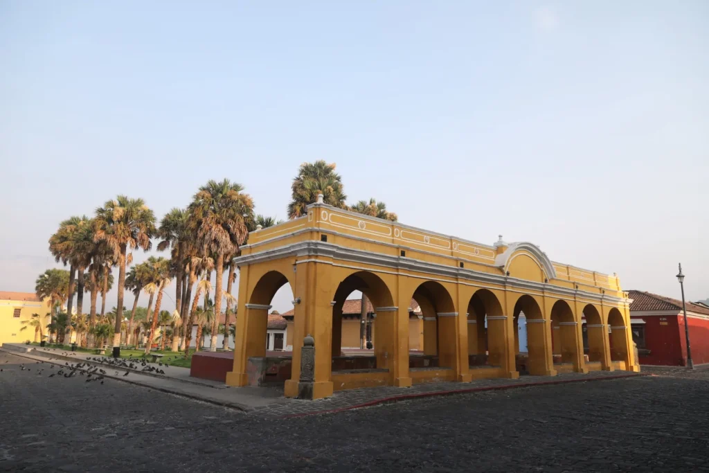 Tanque La Unión, antiguo lavadero colonial amarillo con arcos y palmeras en Antigua Guatemala